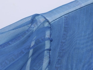 Detailed macro view of the blue floral organza fabric texture and seam craftsmanship