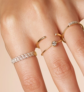Macro view of gold S925 silver rings with pavé diamonds and twisted design on a finger