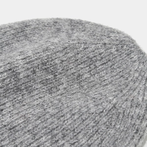 Close-up of gray rib-knit texture on a beanie showing fine stitching and soft fabric