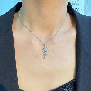 Detail einer silbernen Gänseblümchen-Kette mit Zirkon-Anhängern, getragen am Model-Hals