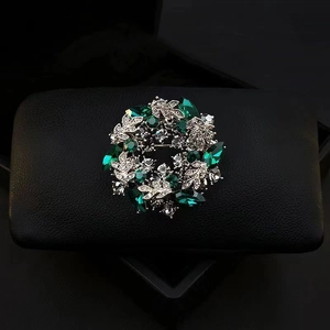 Vintage emerald crystal flower wreath brooch with silver leaves on black leather box