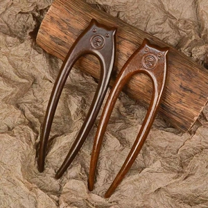 Detailed view of U-shaped sandalwood hairpins with crab claw carving and natural grain