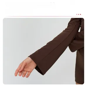 Detailed view of flared cuffs on a dark brown long-sleeve yoga jacket with slim-fit seams