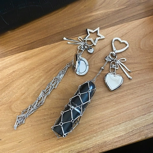 Detail view of heart-shaped metal keychain with functional lipstick holder and mini mirror