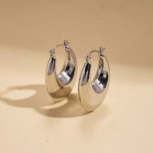 Close-up of polished silver teardrop hoop earrings with high-shine mirror finish metal