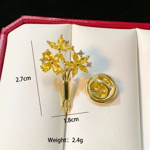 Detailed view of a gold flower brooch with yellow gemstones and size 2.7x1.8cm in a gift box