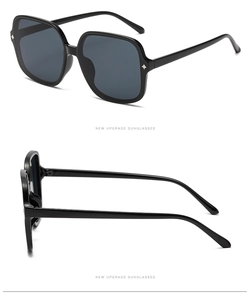 Detail of square sunglasses with black frame and silver star-shaped metal rivets