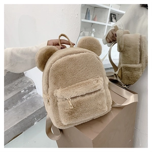 Detail of plush khaki backpack with cute bear ears and golden zippers shown in mirror reflection