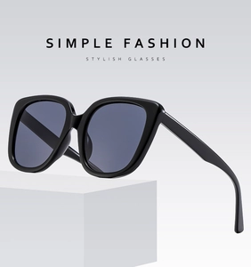 Close-up of oversized square sunglasses with dark purple lenses on a geometric stand
