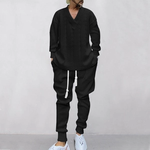 Detailansicht der Passform des schwarzen Jacquard-Strickpullovers und der Hose für Herren