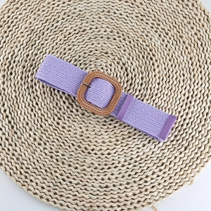 Détail d'une ceinture élastique tressée violette avec une boucle carrée effet bois