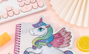 Vista dall'alto di un taccuino a spirale unicorno glitter con tastiera rosa