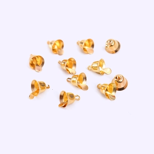 Golden Christmas bell ornaments for DIY crafts and tree decorations on a plain background