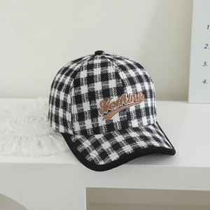 Detailed close-up of British style plaid baseball cap with Nothing letter embroidery