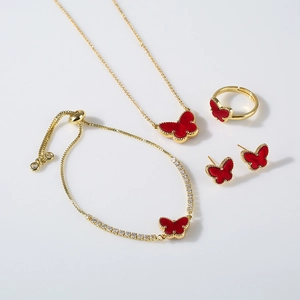 Detail view of gold butterfly jewelry set with red stones and sparkling zircon stones
