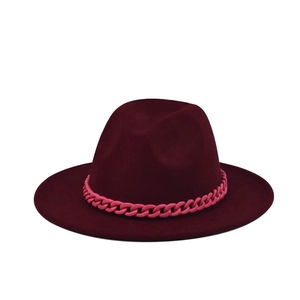 Macro detail of burgundy wool fedora hat featuring a vibrant pink chunky plastic chain link