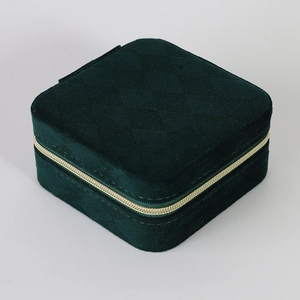 Detail showing dark green velvet jewelry box with quilted pattern and gold zipper