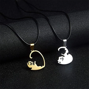 Close-up of heart-shaped cat pendant necklaces in gold and silver finish for couples