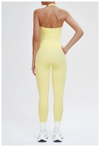 Rear view of light yellow backless yoga top and high-waisted leggings set on model