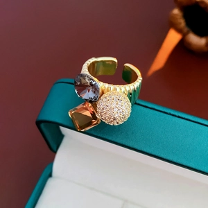 Detailed macro view of gold plated adjustable rings with zircon stones in a green gift box