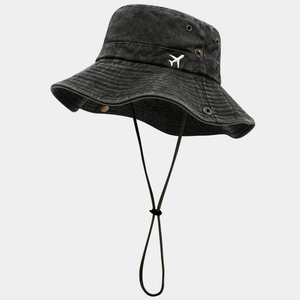 Detail eines gewaschenen Denim-Anglerhuts mit Flugzeug-Stickerei und verstellbarem Seil