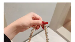 Detalle de la cadena de bolso dorada de lujo con grandes incrustaciones de circón