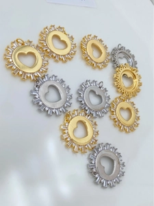 Detailed view of heart-shaped sunburst pendants with cubic zirconia in gold and silver