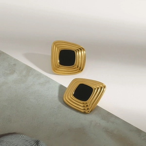 Detail of vintage square stud earrings with black resin inlay and golden steel frame