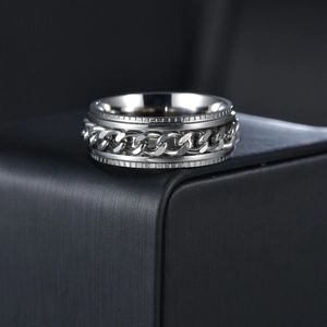 Macro detail of silver stainless steel rotating chain ring on a black brushed display stand