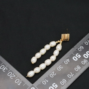 Elegant gold finish drop earrings with white freshwater pearls on a black background