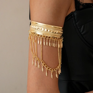 Detail view of gold bohemian leaf tassel armlet showing embossed texture and chains