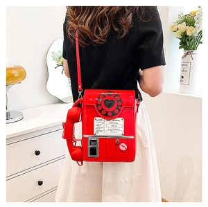 Detailed view of red retro telephone crossbody bag with glossy finish and dial design