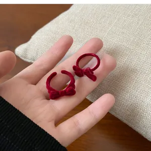 Detailed close-up of red velvet bow open ring with retro elegant flocked texture