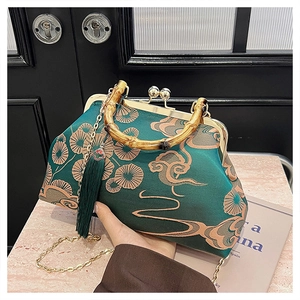 Detail einer dunkelgrünen chinesischen Sticktasche mit Bambusgriff und Seidenquaste