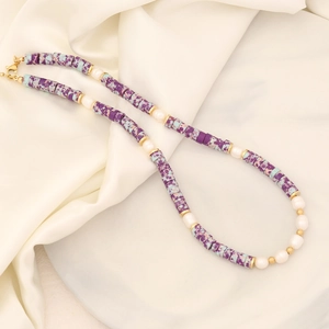 Handmade necklace with purple spotted stone, white pearls and gold beads on silk fabric