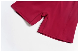 Detailed view of high-density flat seam stitching on deep red yoga shorts for women