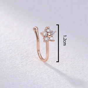 Detailed macro view of a rose gold U-shaped nose ring with a zircon flower charm, 1.2cm size