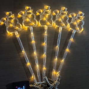 Set of five solar LED snowman lawn lights with warm yellow glow and garden stakes