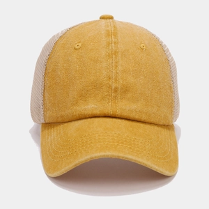 Macro detail of mustard yellow mesh trucker hat showing high-quality stitching and fabric