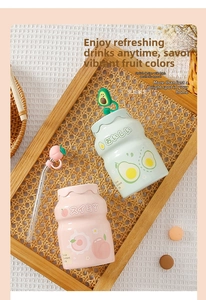 Close-up of Japanese yogurt-style glass mugs with peach and avocado themes and glass straws