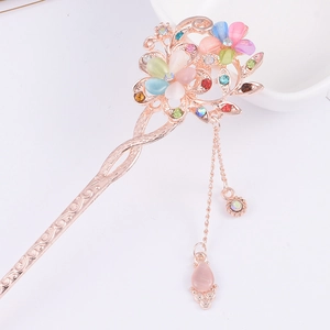 Close-up of golden floral hair stick with colorful gemstones and tassel details