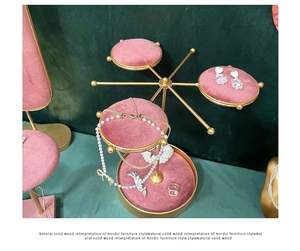 Detail of pink velvet rotating trays and gold metal frame on a jewelry display stand