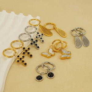 Collection of stainless steel hoop earrings featuring cross, butterfly, and wing charms