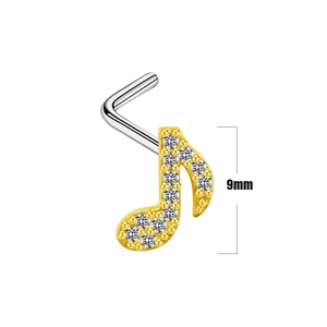 Détail macro d'un piercing nez note de musique 9mm avec zircons et finition dorée