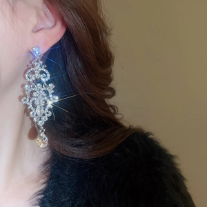 Macro shot of silver crystal tassel earrings with a water drop pendant on a model