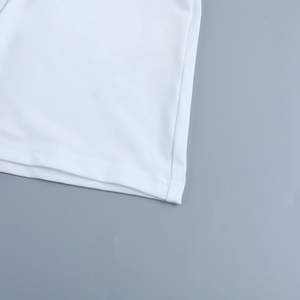 Detail of white dress showing professional double-needle stitching and knit fabric texture