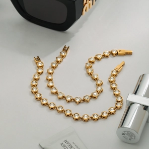Close-up of gold stainless steel bracelets with heart-shaped and round zircon stones