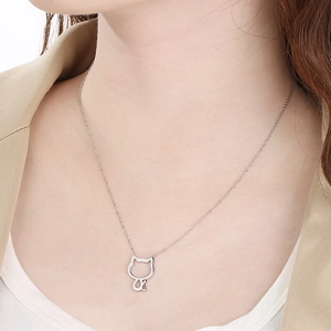 Close-up of minimalist stainless steel necklace with a hollow cat pendant on a model