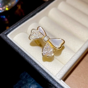 Macro shot of gold bow ring with sparkling crystals and mother of pearl in a jewelry box