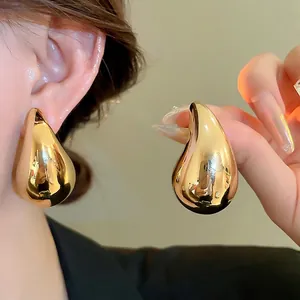 Polished gold-tone oversized teardrop earrings with a minimalist sleek metallic finish